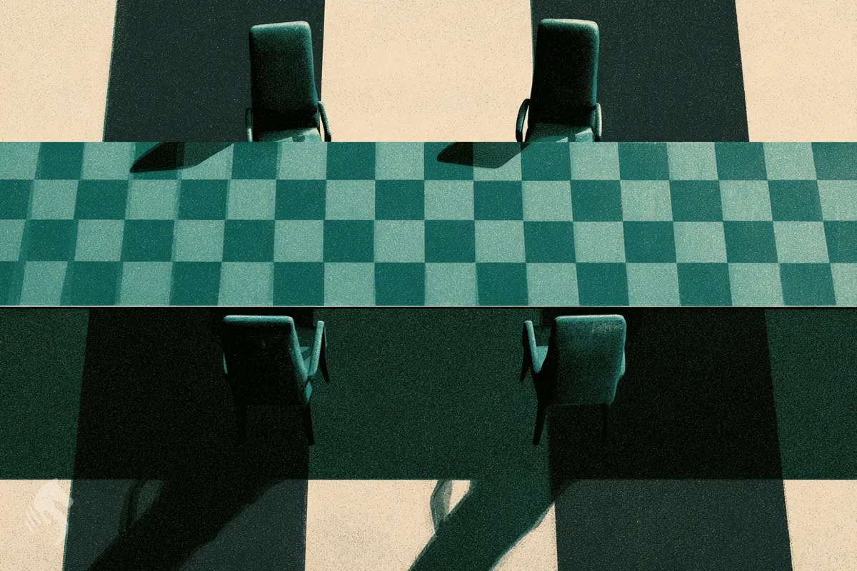 Une longue table de négociation vue de dessus dont le plateau est un damier.