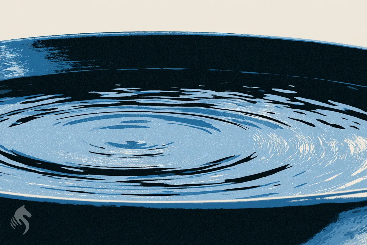 Un bol d'eau vu de près dont la surface vient de redevenir parfaitement immobile.